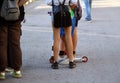 A group of young people are standing on a town street during the day. Teenagers hang out at an entertainment event.