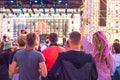 Young people at a street music festival raised their hands up and dance