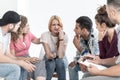 Young people supporting crying teenage girl during meeting with therapist Royalty Free Stock Photo