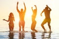 Young people swimming at sunrise party on the beach - Group of multi race friends having fun on vacation - Friendship and holidays Royalty Free Stock Photo