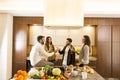 Young people toasting with white wine in the kitchen Royalty Free Stock Photo