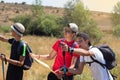 Young people with trekking poles doing the Camino de Santiago in Spain and reading the map to orientate themselves and indicating