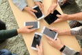 Young people using mobile phones at wooden table. Concept of addiction Royalty Free Stock Photo