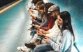 Young people using mobile smartphone while sitting in subway waiting train