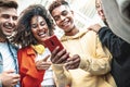 Young people using smart mobile phone device outdoors - Happy teenagers having fun together watching video stories on social media Royalty Free Stock Photo