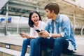 Young people are using smartphone and smiling while sitting on free time. Royalty Free Stock Photo