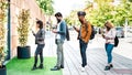 Young people waiting in line practising social distancing at city shop - New normal lifestyle concept with people wearing facemask