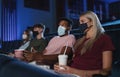 Young people watching film in the cinema, coronavirus concept. Royalty Free Stock Photo