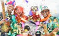 Young people wearing colorful costumes celebrating carnival party event throwing confetti Royalty Free Stock Photo