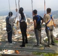 Young people wearing a harness in a viewpoint of a city, tourist lookout.