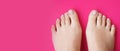 Young perfect groomed womans feet on pink background. Care about nails