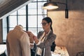 Young perfectionist. Serious young woman in eyewear adjusting a