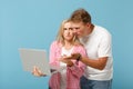 Young perplexed couple friends guy girl in white pink empty blank t-shirts posing isolated on pastel blue background Royalty Free Stock Photo