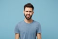 Young perplexed disgusted irritated man in casual clothes posing isolated on blue wall background, studio portrait