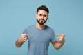 Young perplexed unconfident man in casual clothes posing isolated on blue background, studio portrait. People sincere