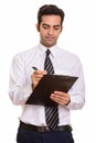 Young Persian businessman writing report on clipboard Royalty Free Stock Photo