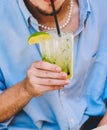 young person enjoying a rum, lime and mint mojito