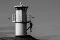 Young person hanging from a lighthouse