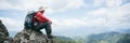 Young person hiking male on top rock, Backpack man looking at beautiful mountain valley at sunlight in summer, Landscape with Royalty Free Stock Photo