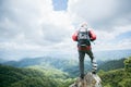 Young person hiking male on top rock, Backpack man looking at beautiful mountain valley at sunlight in summer, Landscape with Royalty Free Stock Photo