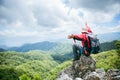 Young person hiking male on top rock, Backpack man looking at beautiful mountain valley at sunlight in summer, Landscape with Royalty Free Stock Photo