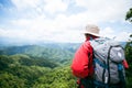 Young person hiking male on top rock, Backpack man looking at beautiful mountain valley at sunlight in summer, Landscape with Royalty Free Stock Photo