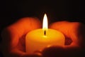 Young person holding burning candle in darkness Royalty Free Stock Photo