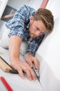 young person installing floor carpet with cutter Royalty Free Stock Photo