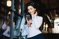 Young petty brunette businesswoman in elegant clothes standing a