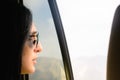 Young petty caucasian woman face with glasses stare surprised from car window to right side nature empty space