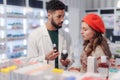 Young pharmacist helping customer to choos medication.