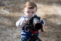 Young photographer child taking photos with camera on a tripod Royalty Free Stock Photo