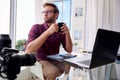 Young photographer holding coffee at his home studio Royalty Free Stock Photo