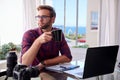 Young photographer holding coffee at his work desk Royalty Free Stock Photo