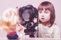 Young photographer. lCute little child girl is shooting portrait of toys dolls with a DSLR camera