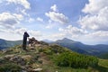 Young photographer man standing on top of cliff taking pictures of the ridge mountain range of Chernogor in Ukraine. Carpathian Royalty Free Stock Photo