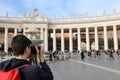 Young photographer in Saint Peter Square in the Vatican City whi Royalty Free Stock Photo