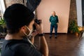 Young photographer taking picures of elderly woman, backstage of photoshooting in studio. Royalty Free Stock Photo