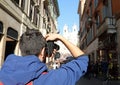 Young photographer in Via dei Condotti in Rome and the church i