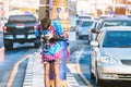 A young photographer in wet clothes use DSLR camera to take pictures of Songkran water splashing festival on the road