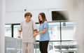 Young physical therapist helping senior patient in using walker during rehabilitation Royalty Free Stock Photo