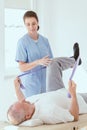 Physiotherapist exercises in a bright medical office with his injured patient