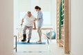 Physiotherapist exercises in a bright medical office with his injured patient