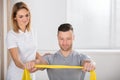 Young Physiotherapist Giving Training With Exercise Band To Man Royalty Free Stock Photo