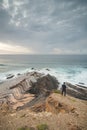 Young pilgrim stands on top of a cliff and watches the Atlantic Ocean. Praia da Amoreira near the town of Aljezur in the Odemira