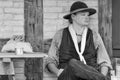 Young Pioneer Settler Sitting by Cabin