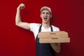 Pizza delivery man holds boxes and shouts, the courier shows a victory sign and delivers the order on a red background Royalty Free Stock Photo