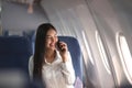 Young plane passenger business woman using smartphone communicate, businesswoman working while flying at plane