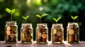 Young plants growing from coins in several savings jars, saving money for future, alternative investments and sustainability