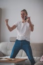 Young player in a white T-shirt rejoices in winning ice hockey on a game console. Professional e-sport player. Rejoicing in a Royalty Free Stock Photo